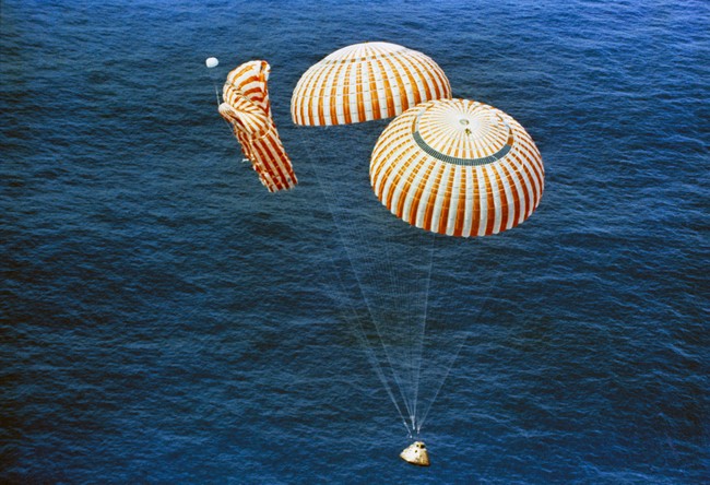 Apollo 15 capsule on its way to splashdown in the ocean with only 2 of 3 parachutes deployed properly