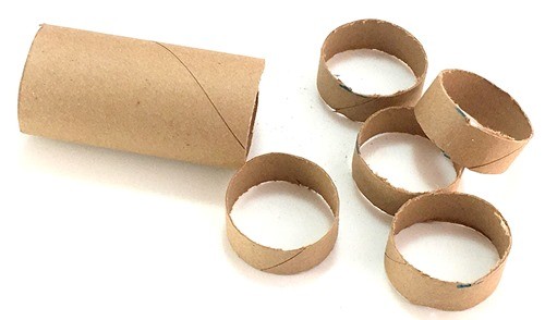 A longer section of cardboard tube with 5 shorter sections placed next to it.