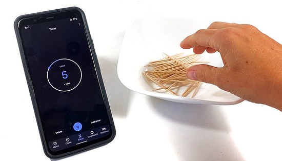 A hand reaching for toothpicks in a bowl. A timer next to the bowl shows 5 seconds
