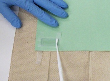 Drops of liquid being applied to a glass slide.  