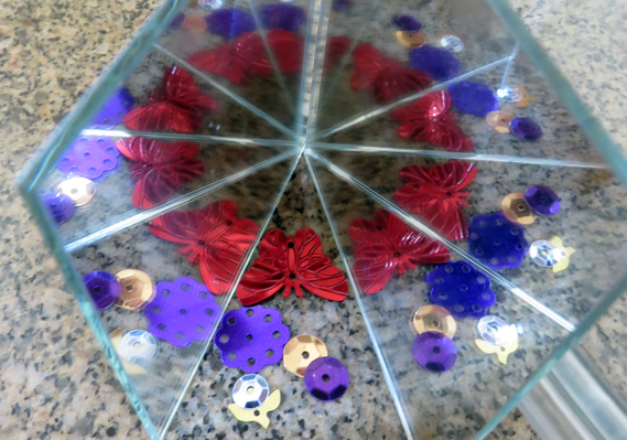 Set of mirrors reflecting small objects in repetition like an infinity mirror or kaleidoscope