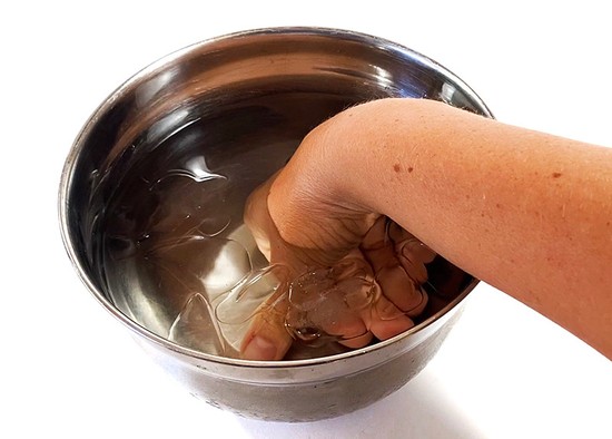  A hand submerged in an ice-bath. 