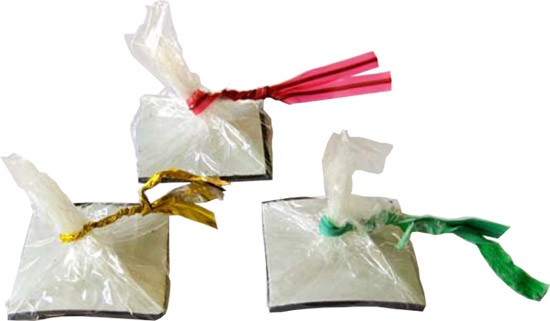 Three squares of magnetic tape wrapped in plastic and tied closed