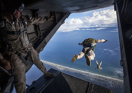 Paratroopers jumping from the back of a cargo plane