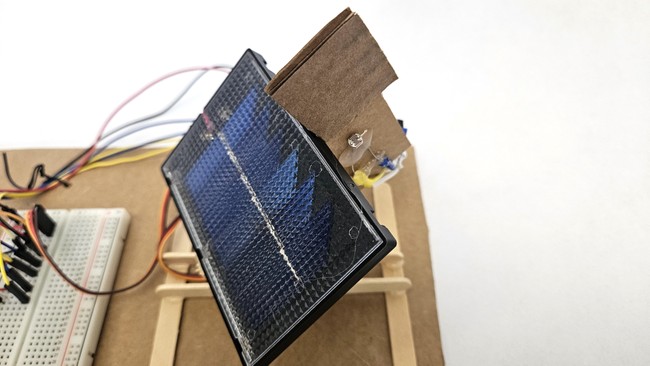 Piece of cardboard mounted perpendicular to the solar panel