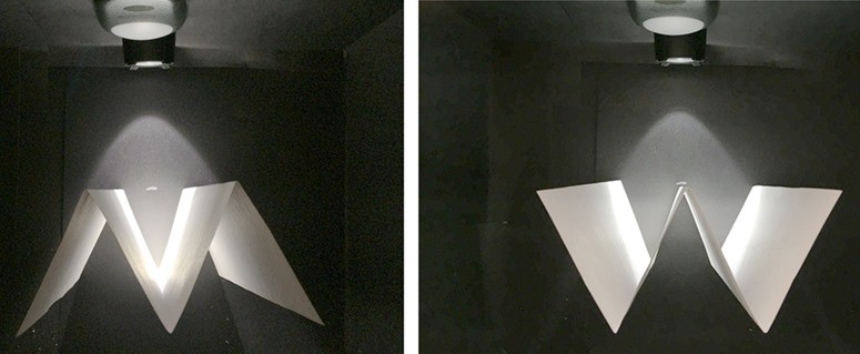 Two views of white paper folded in W shape inside a black box.