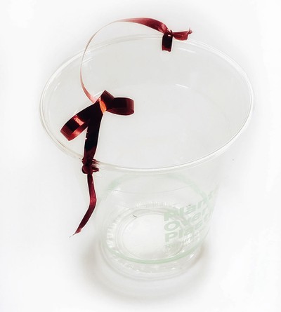 A cup to which a string is knotted. The string serves as a handle.