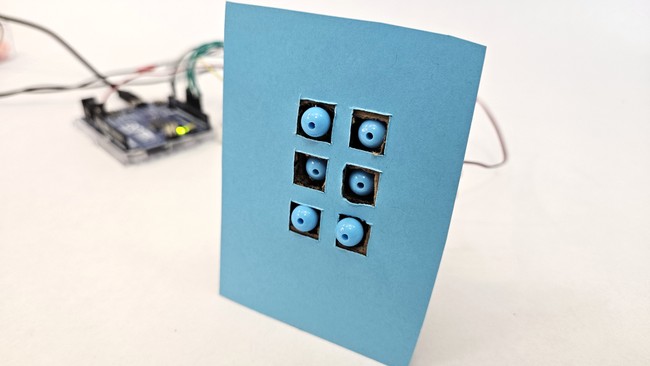 refreshable braille display made from cardboard and plastic beads