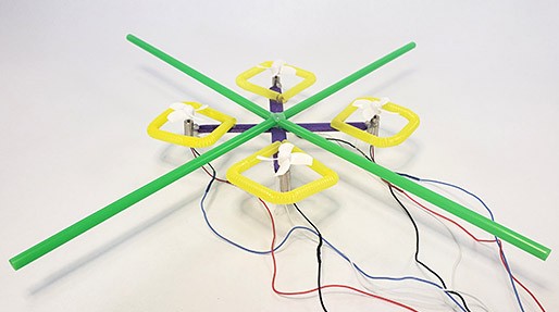 A mini popsicle stick drone with a straw 'roll cage' to prevent propeller damage