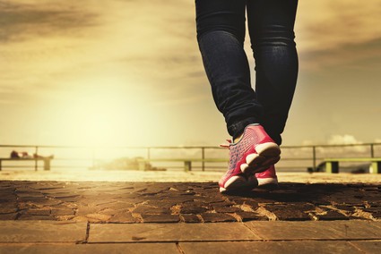 lower body of person walking with athletic shoes