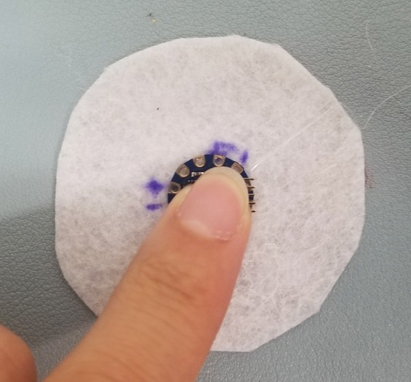 Hot gluing TinyLily onto felt piece A.