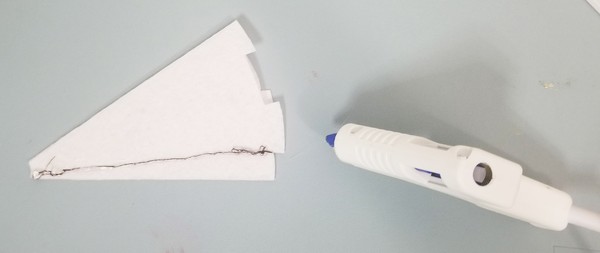 Hot gluing down the stitches.