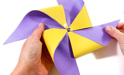 Paper pinwheel with a thumbtack through its center.