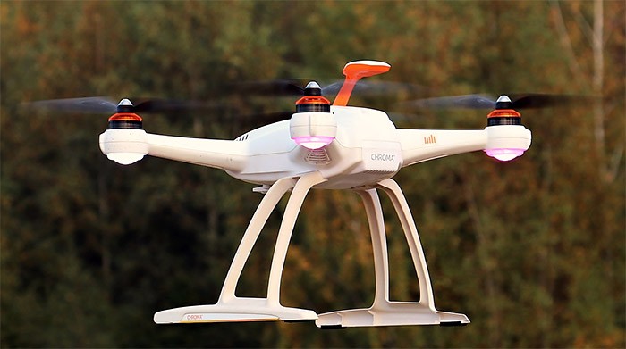 A small drone with 4 rotors hovering in the air.