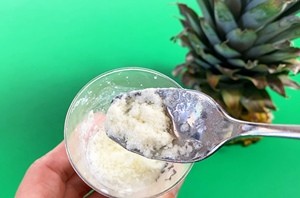 Curdled milk scooped on a spoon above a plastic cup