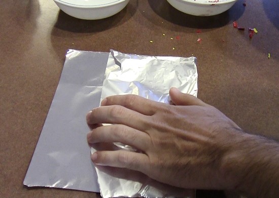 Aluminum foil folded in half over the pile of crayon shavings.
