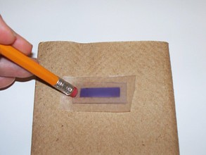 Using a utility knife to lift parafilm from the top of a glass slide.