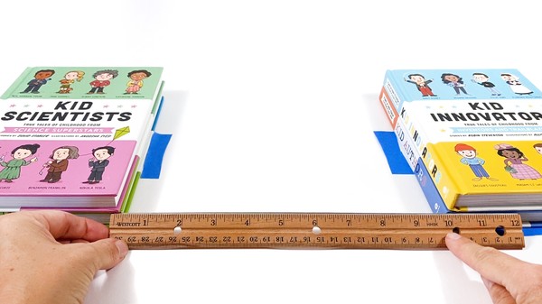 Two 2-inch-high stacks of books spaced about 10 inches apart. The location of the books is marked with tape.