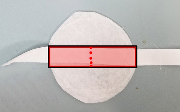 Midpoint of ribbon indicated hot glued onto felt piece B.
