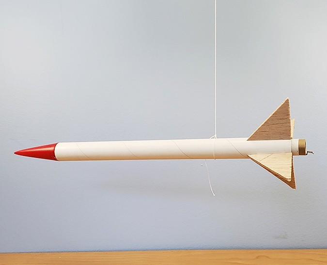 A rocket balanced about its center of mass while hanging from a string