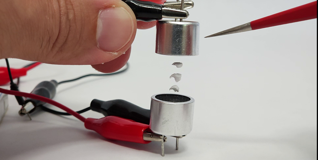 bits of foam levitating between two ultrasonic transmitters