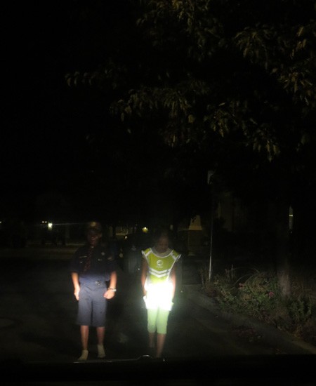two pedestrians in the dark wearing bright safety gear