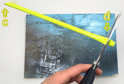 Scissors cut one end of a straw into a point and cut a horizontal slit on the opposite end